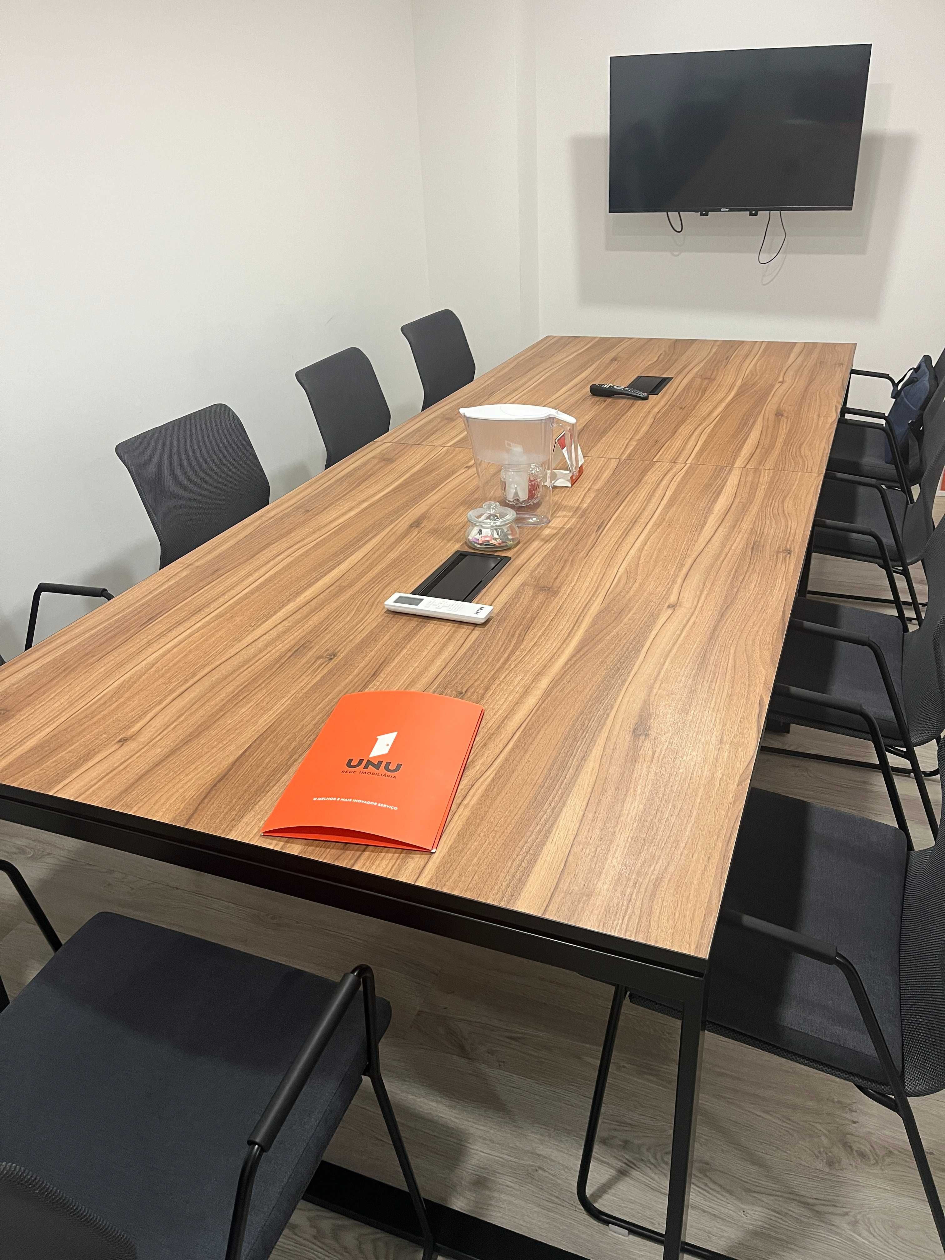 Mesa de reunião com 3,20 m x 1,20 m, acompanhada de 8 cadeiras.