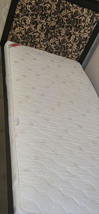 Stylowe łóżko ze stelażem i materacem.