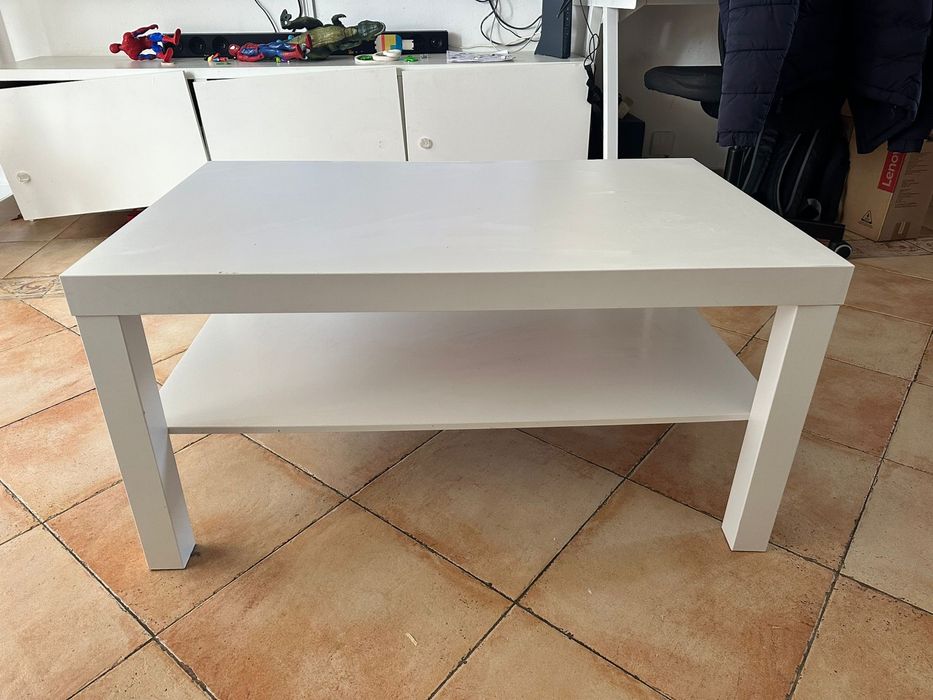 Mesa de centro branca, com uma prateleira inferior.