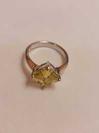 Srebrny pierścionek z żółto-zielonym kamieniem.