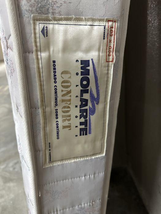 Cama de madeira, colchão e mesinha de cabeceira