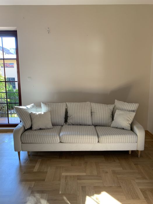 Elegancka jasna sofa na nóżkach z funkcją spania- rozkładana