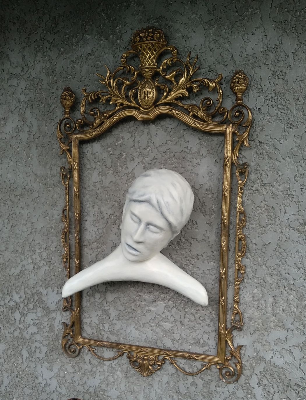 Escultura com moldura em metal amarelo