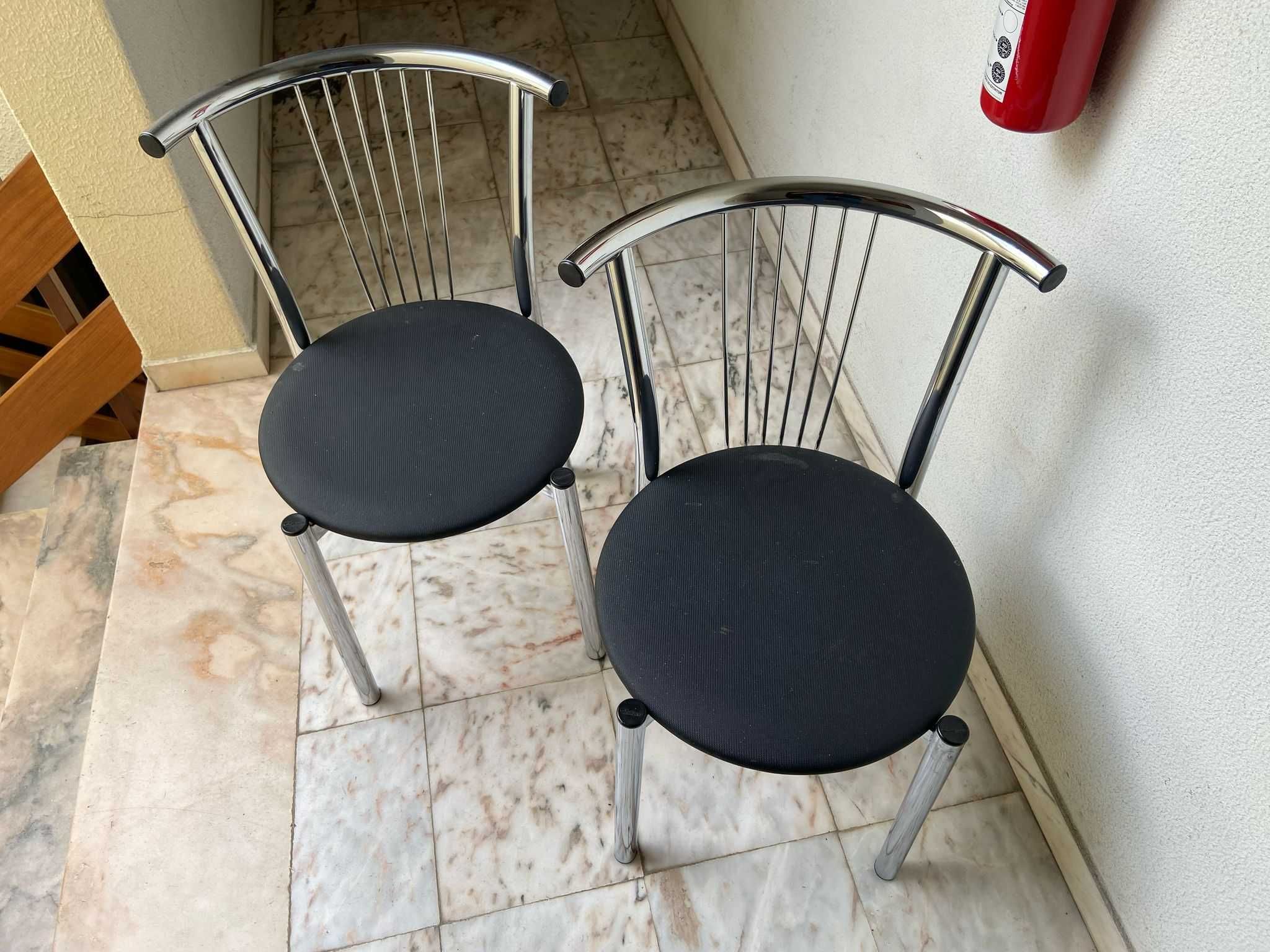 Duas cadeiras de metal, com tampo preto