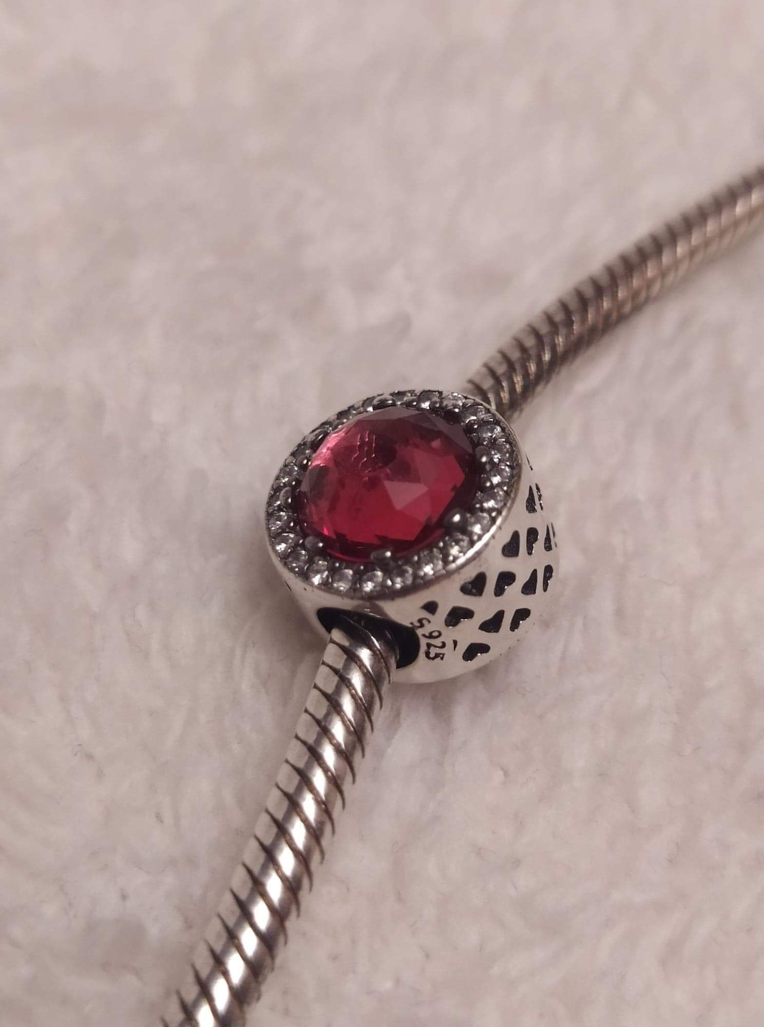 Koralik srebrny charms z czerwono różowe  oczkiem ala rubinowe. Czerwo