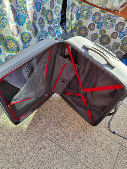 Mala de viagem cinzenta rígida com muito boa capacidade .