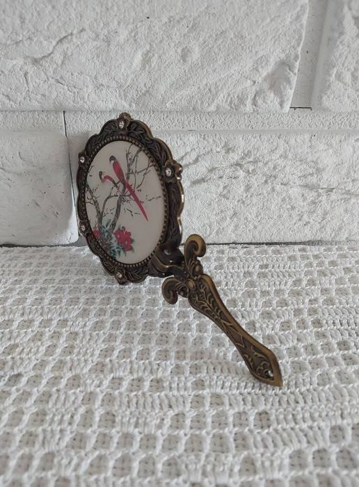 Lusterko z metalowej oprawie.