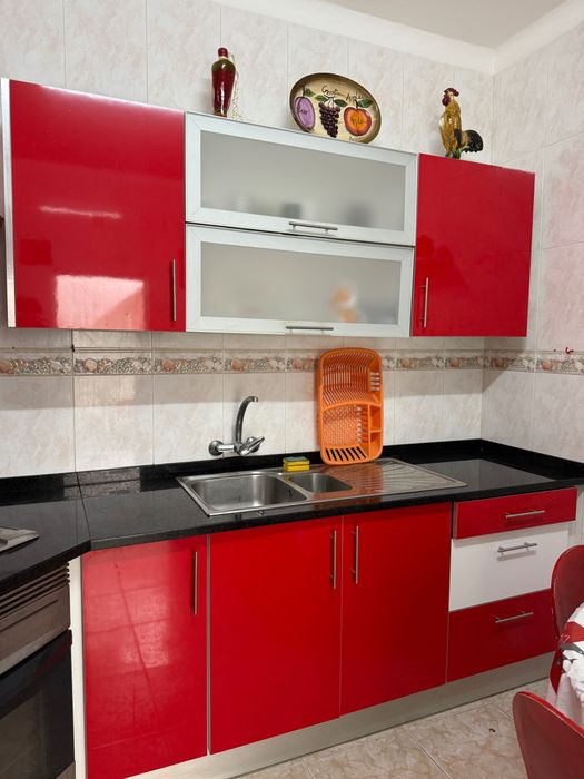 Cozinha moderna vermelha com bancada em granito preto