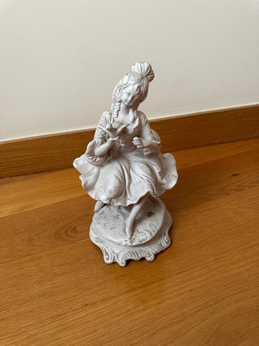Estatueta de menina a segurar uma pomba