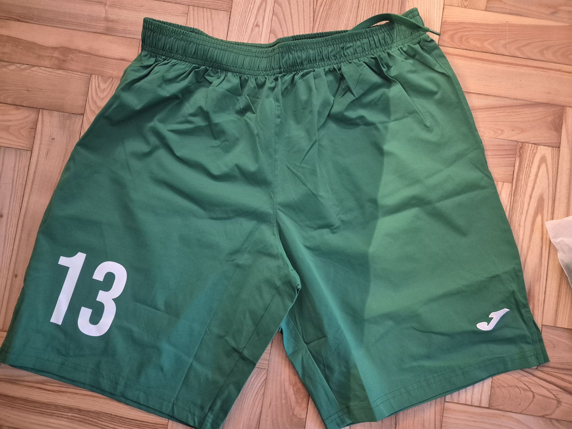 Nowe spodenki sportowe z metką firmy Joma z numerem 13, rozmiar L.