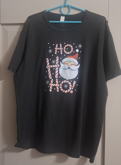 Czarna koszulka świąteczna z nadrukiem Mikołaja i napisem „HO HO HO”.
