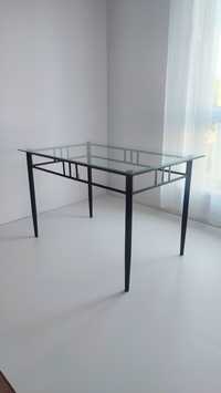 Szklany stół z metalowymi nogami