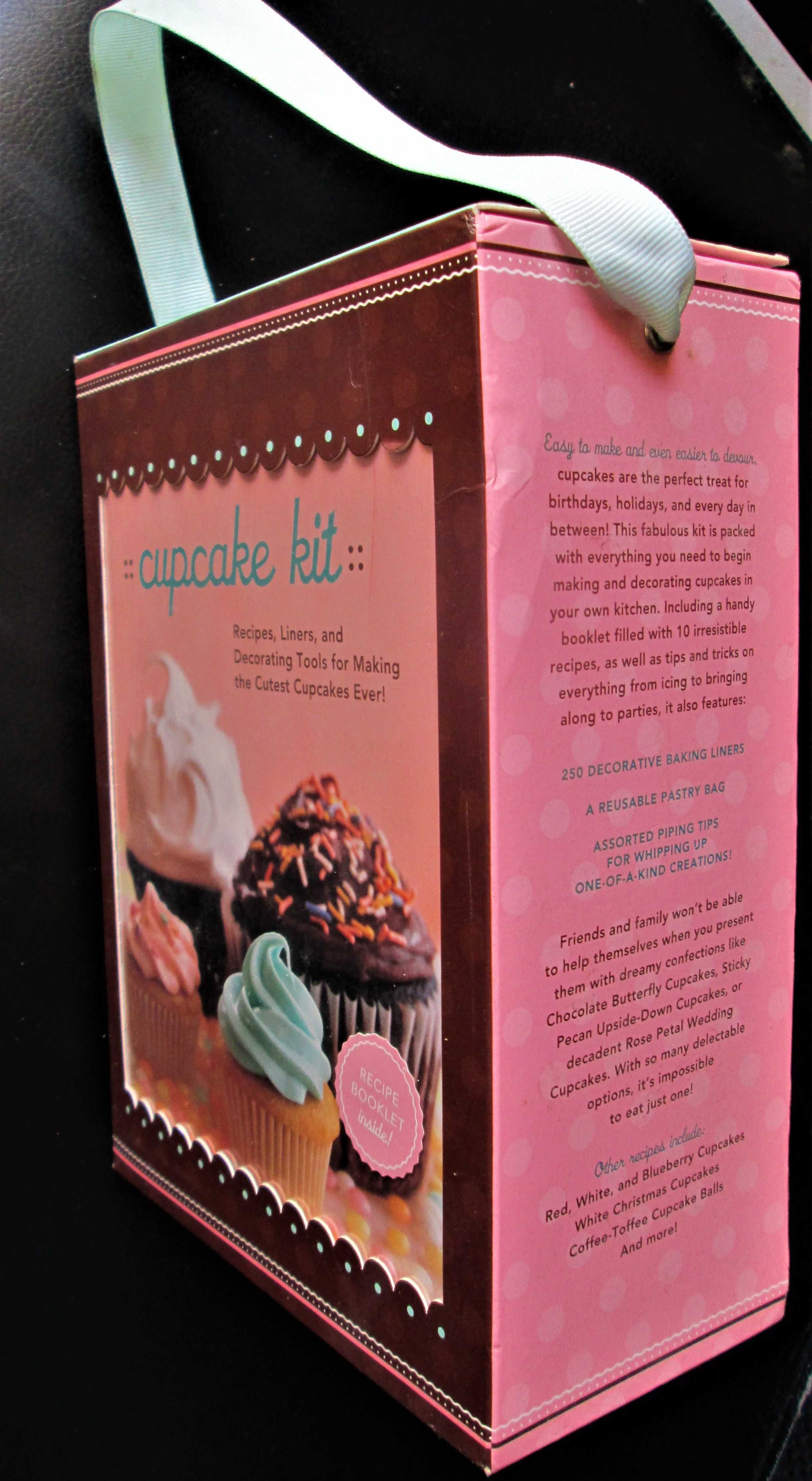 Cupcake, uma caixa com livro de receitas, saco de pasteleiro e formas