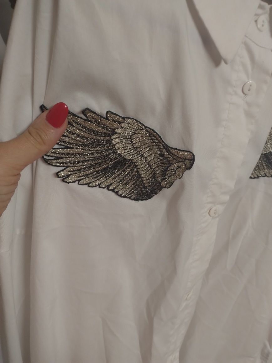 Koszula oversizowa, biała, elegancka ze srebrnymi skrzydłami.