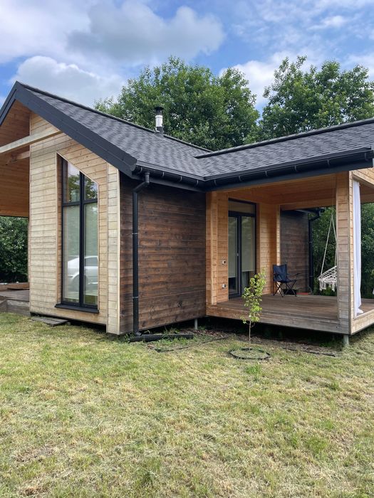 Сучасний будинок 45 м² з каміном і терасою біля лісу.