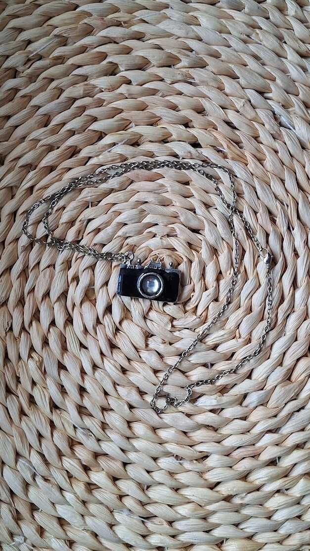 Wisiorek aparat fotograficzny na długim metalowym srebrnym łańcuszku