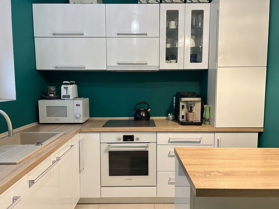 Kuchnia z wyspą kuchenną i krzesłami