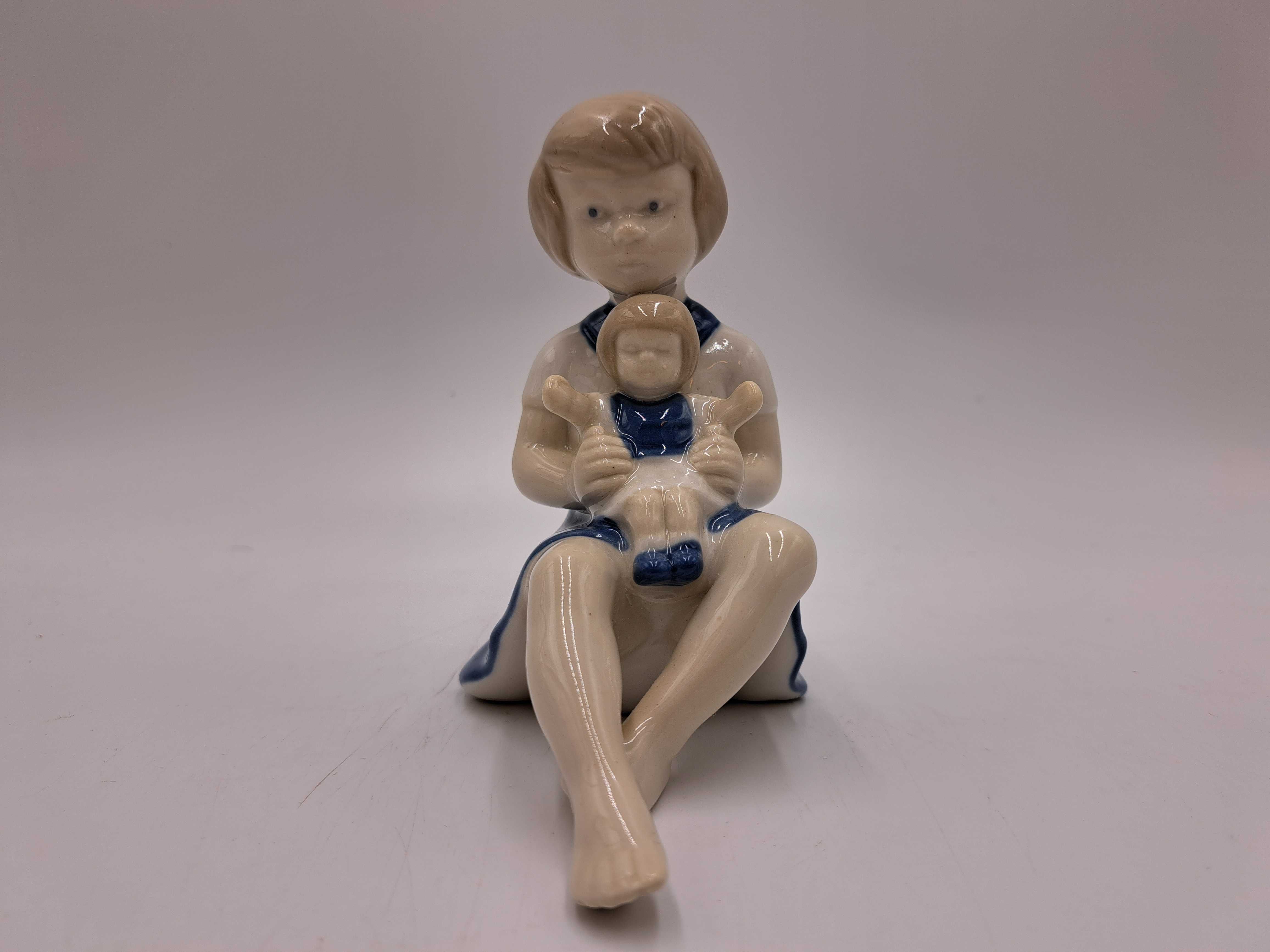 Figurka porcelanowa dziewczynka z lalką na kolanach GDR Wagner&Apel