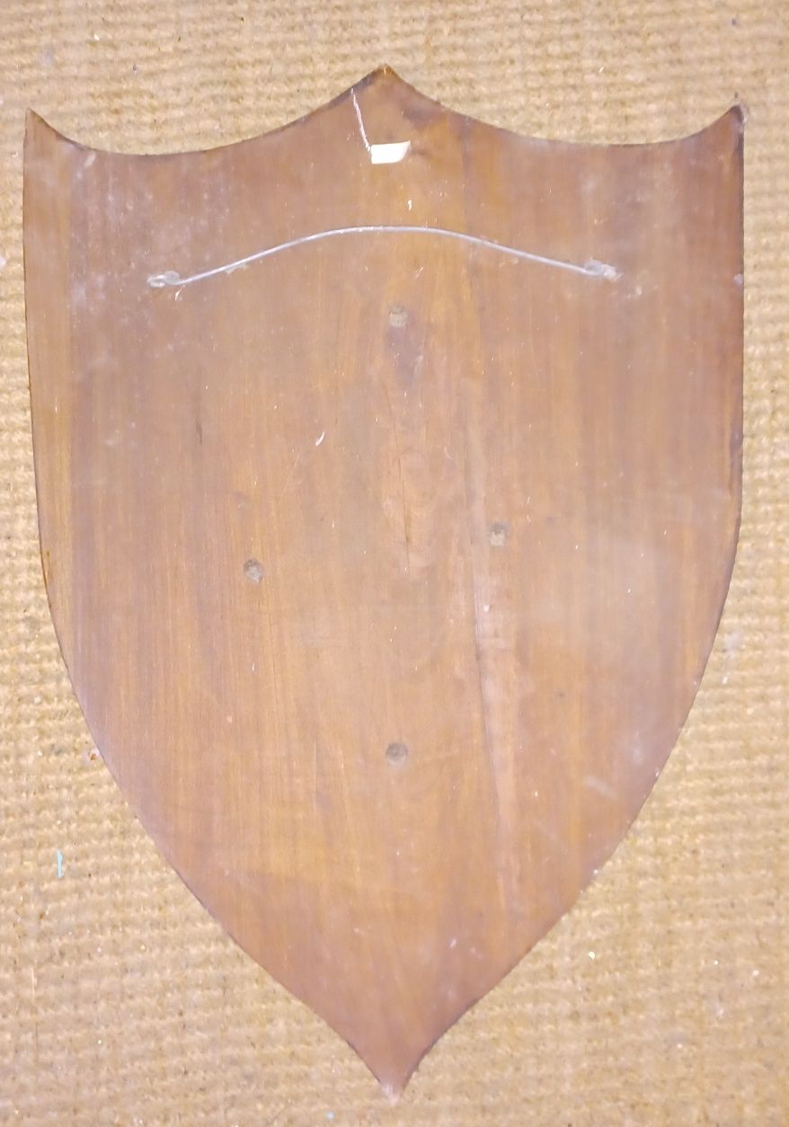 Placa de madeira em formato de escudo com cabeça de cavalo em placa de