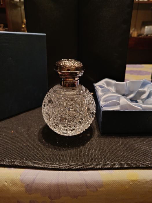 Флакон для духов с серебряной крышкой.