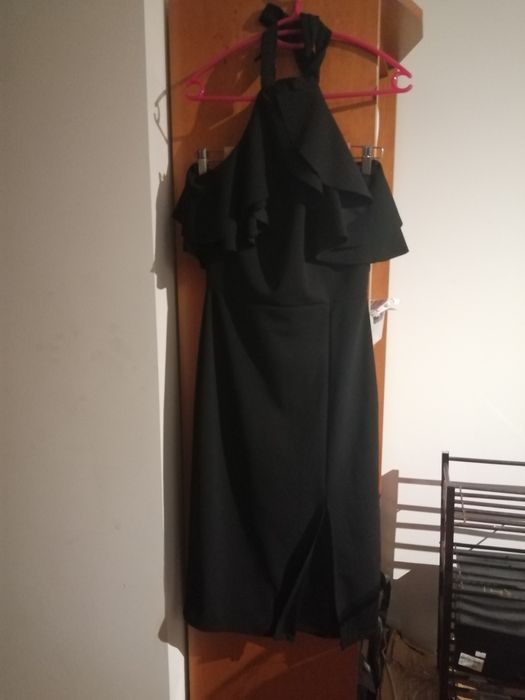 Vestido preto, elegante, com folho no peito. Alça a atar no pescoço.