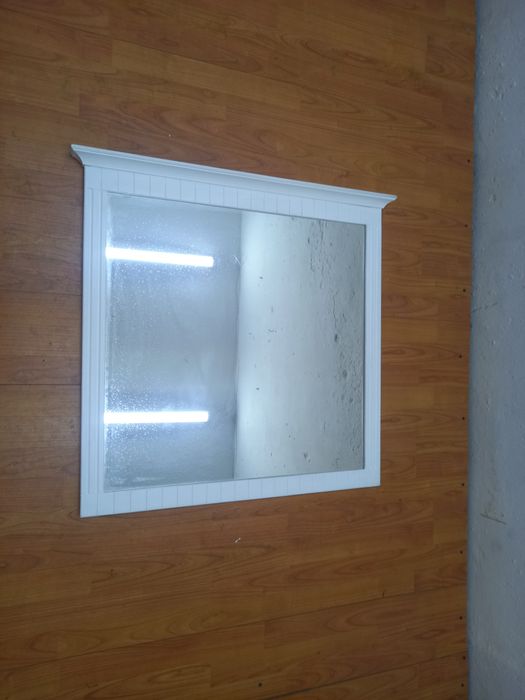 Lustro w drewnianej ramie.