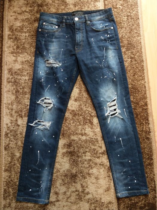 spodnie jeansowe z przetarciami dziurami i kropkami imitujacymi farbe