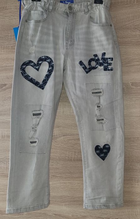 Nowe spodnie jeansowe damskie z dziurami i naszywkami,rozmiar L