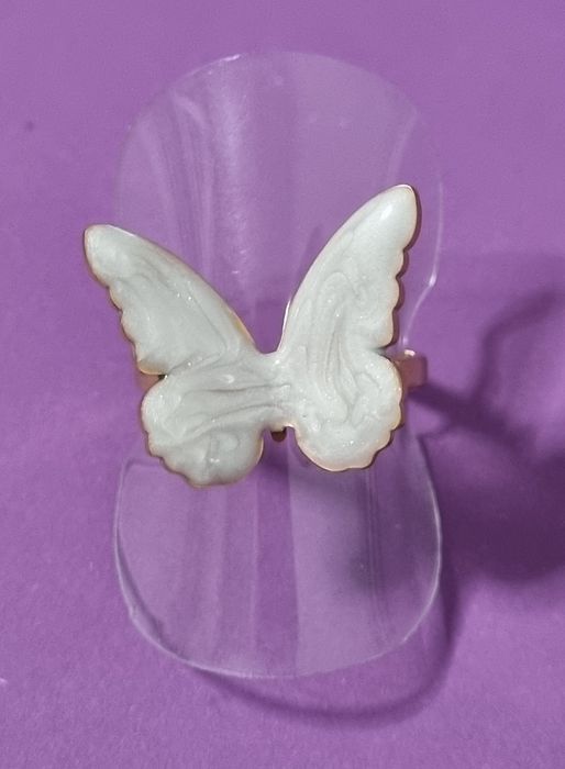Anel dourado, em açol, com borboleta branca esmaltada. Ajustável