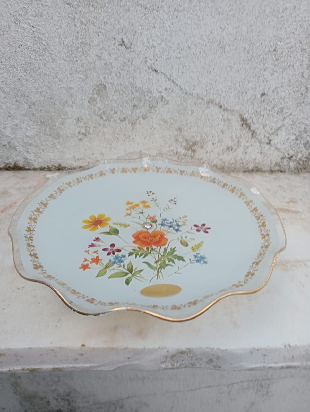 Fruteira em vidro com o pé em metal, com motivos florais.