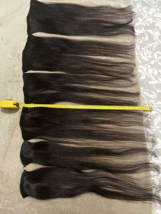 Extensões castanhas escuras de cabelo verdadeiro.