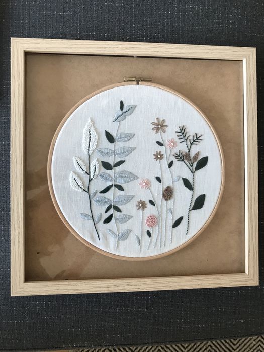 Quadros bordados à mão com motivos de flores.