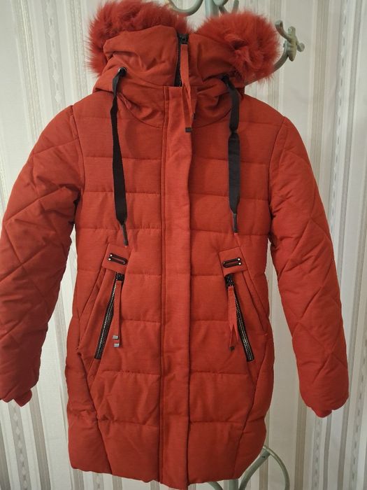 Куртка-парка червоного кольору з капюшоном, оздобленим хутром.