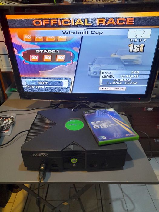 Consola de jogos X-BOX antiga desbloqueada usada com cabos e comando.