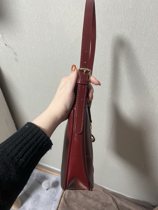 Сумка бордового кольору.