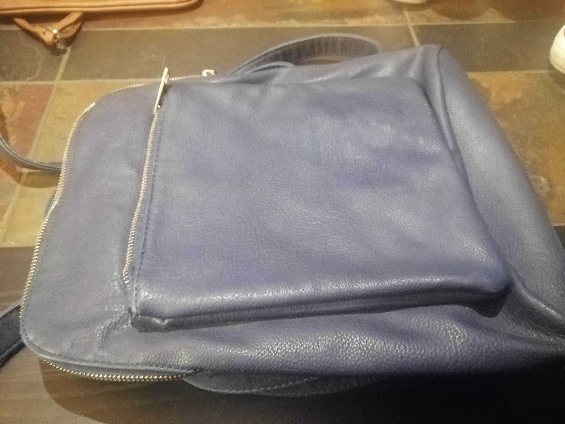 Uma mala/mochila de cor azul escuro e uma mala pequena de cor castanha