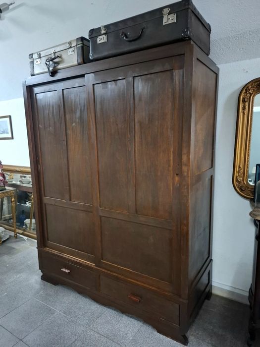 Roupeiro em madeira maciça com portas de correr.