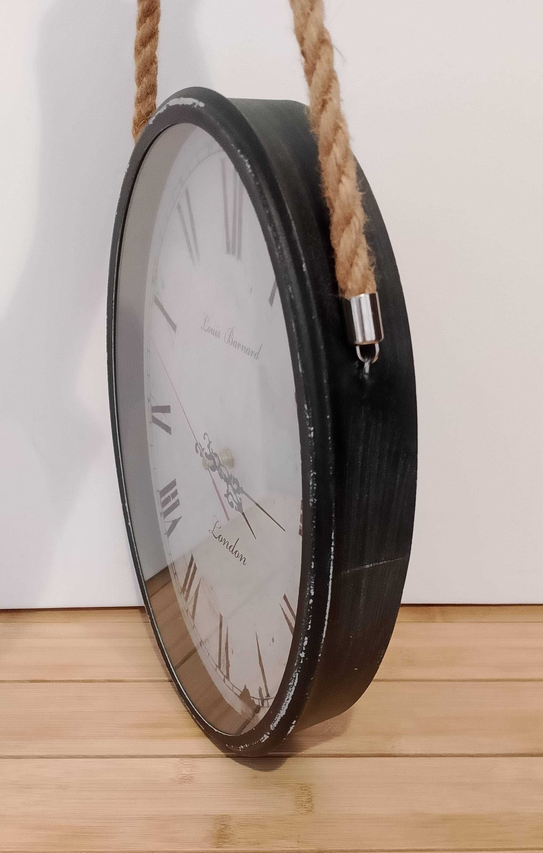 Duży zegar ścienny, wiszący na sznurze, styl vintage.