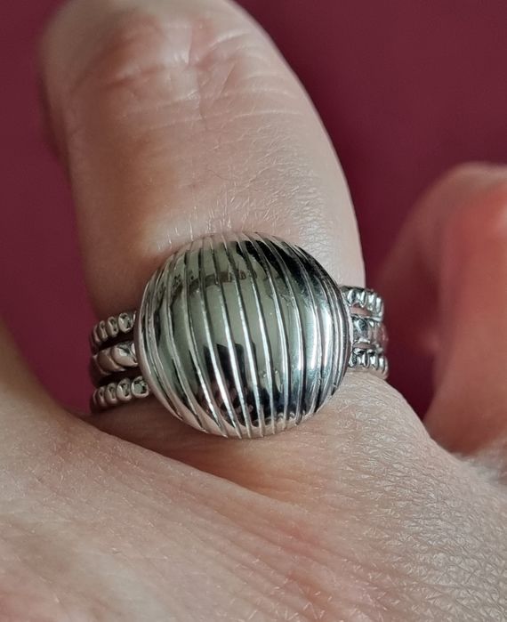 Anel prateado, em aço, com meia bola riscada. Ajustável