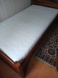 łóżko z materacem i skrzynią na pościel