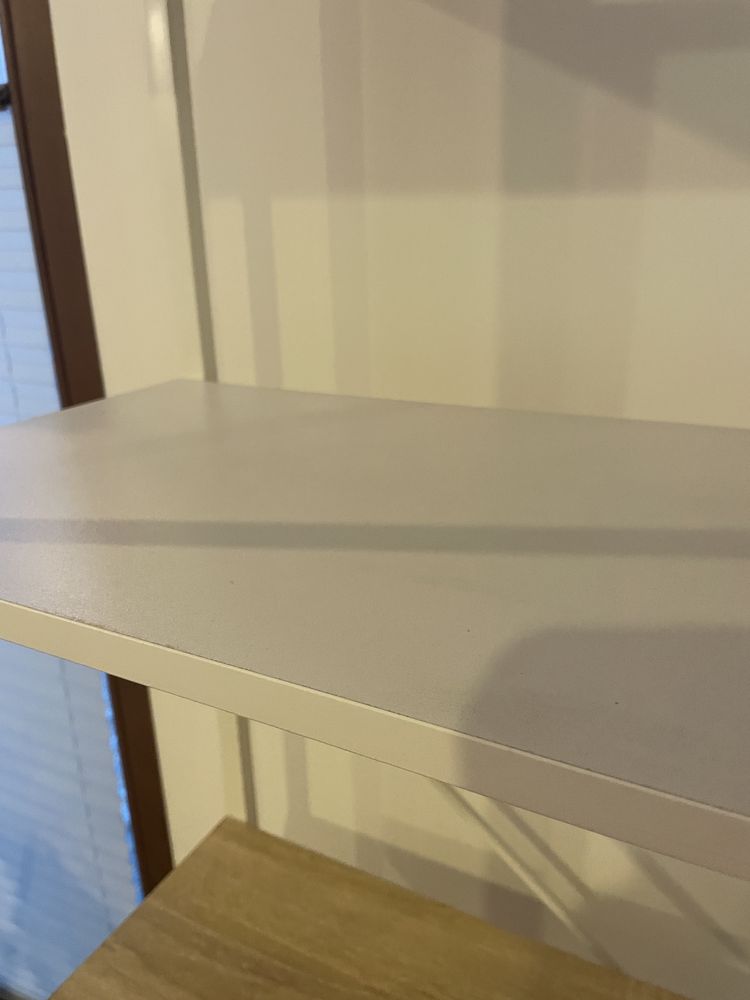 Biała, metalowa szafka na ksiazki z drewnianymi i białymi półkami