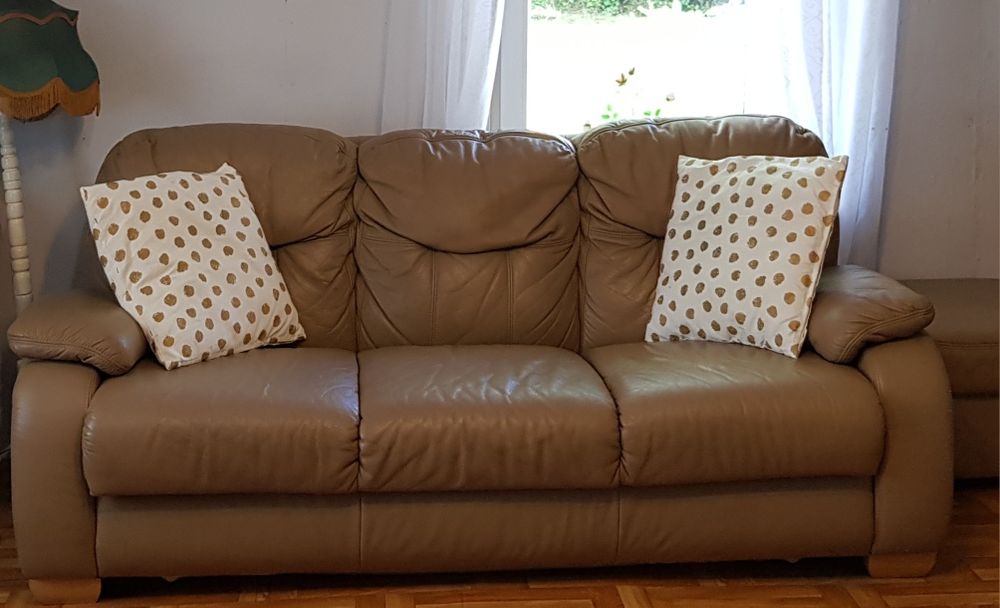 Skórzane kanapa, fotel i dwie pufy.