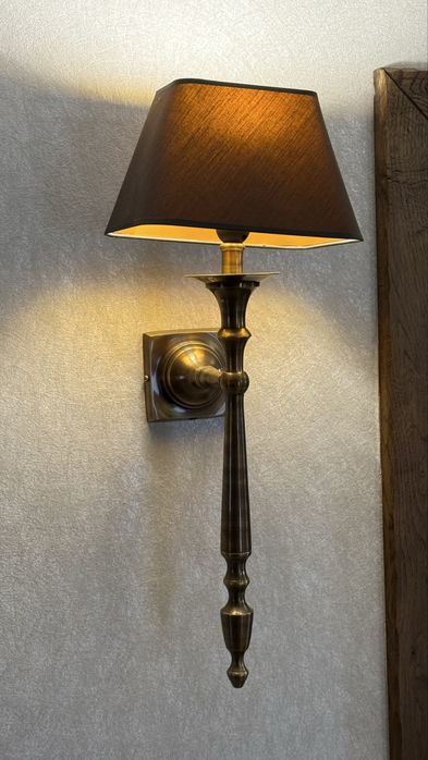 To jest mosiężny kinkiet ścienny z brazowym abażurem.