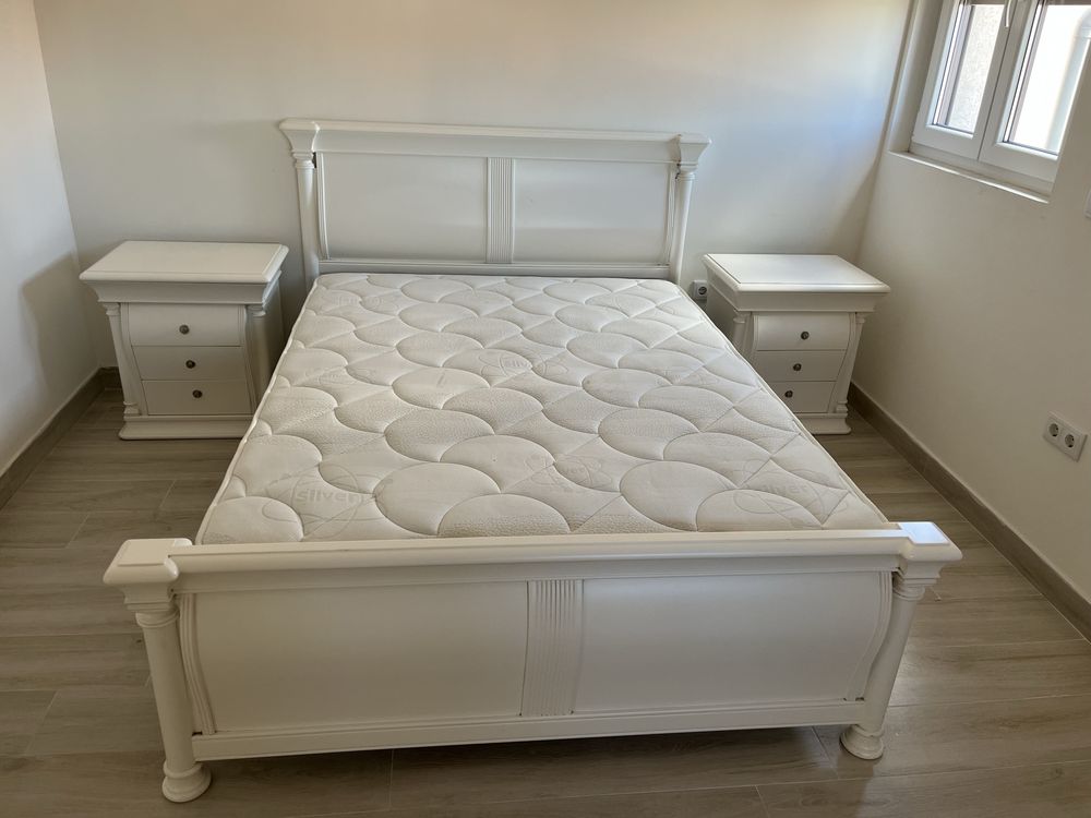 Mesa de cabeceira branca e cama