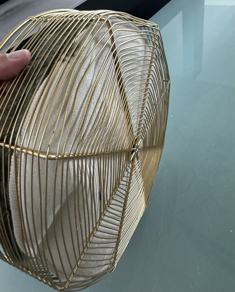 Peça decorativa em metal ountado a diurado com tecido sveludado.