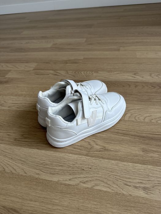 Дитяче взуття: білі кеди, чорні туфлі на дівчинку