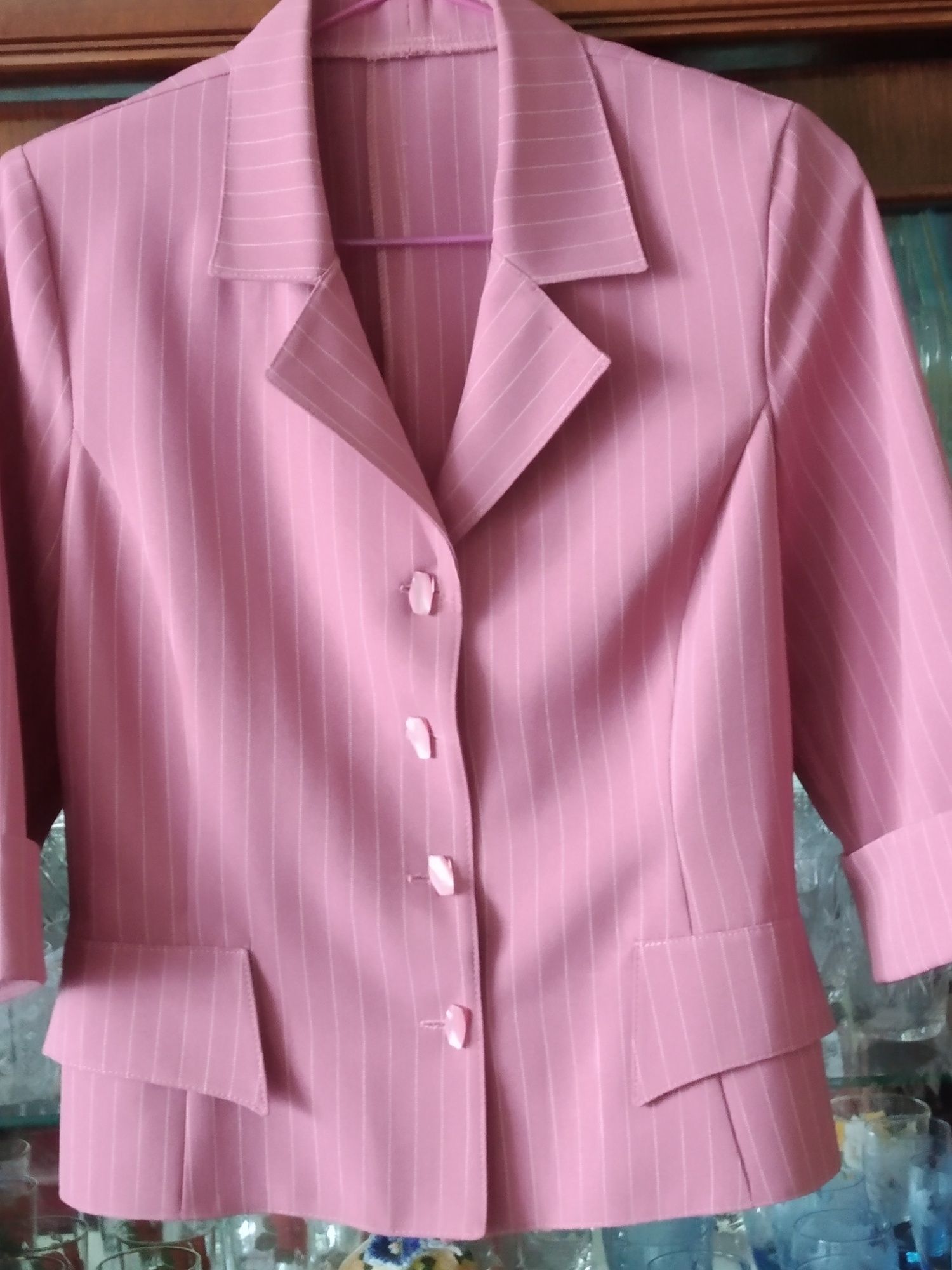 Розовий жіночий костюм з юбкою.
