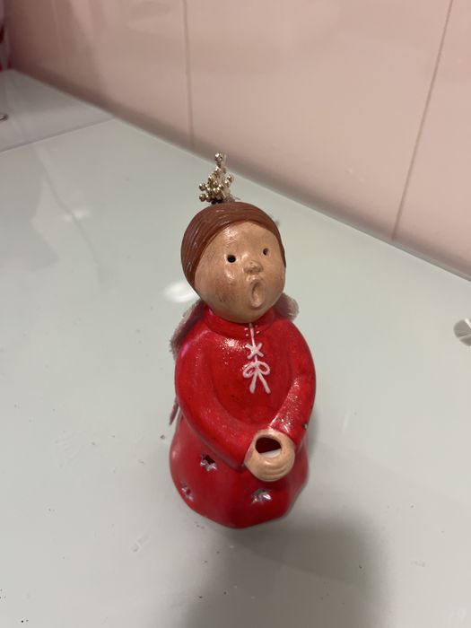 Anjo com suporte para vela tem desenhado buracos em forma de estrla po