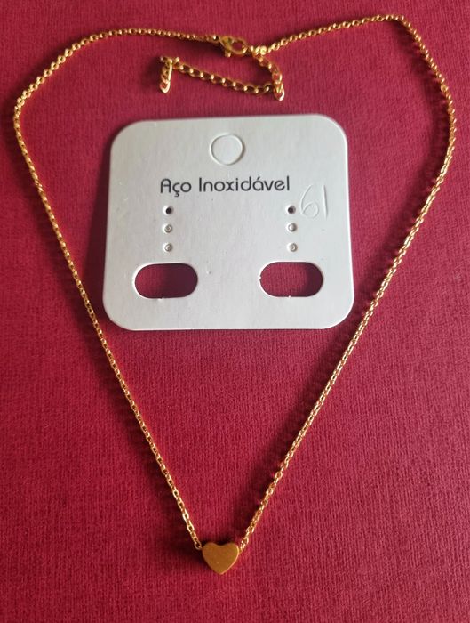 Colar dourado, em aço, com pequeno coração fixo. Tem extensor