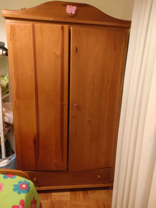 Quarto com cama, mesa de cabeceira e roupeiro